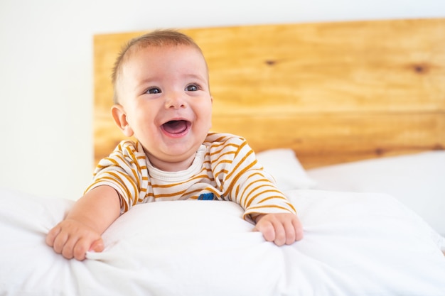 Close-up shot van een schattige lachende baby op een bed