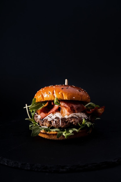 Close-up shot van een smakelijk uitziende hamburger geïsoleerd op een zwarte ondergrond