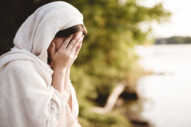Gratis foto close-up shot van een vrouw die een bijbelse mantel draagt die bidt
