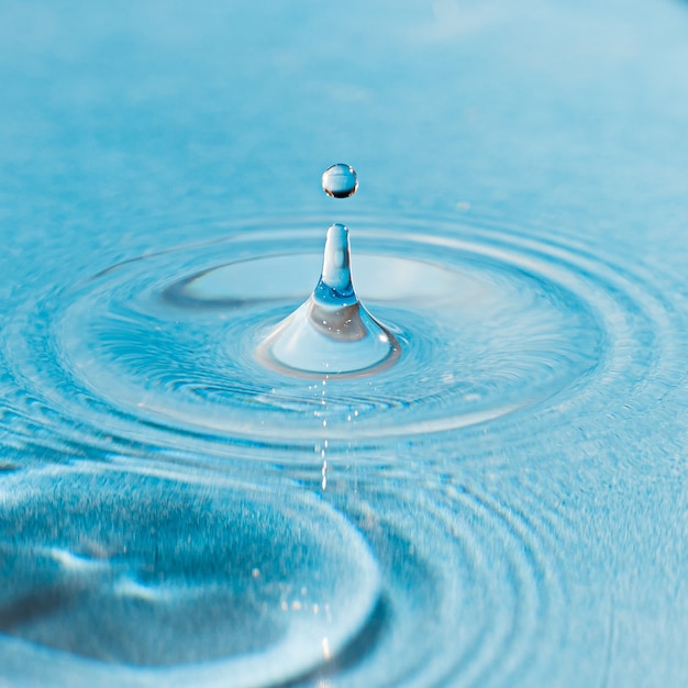 Close-up shot van een waterdruppel in het blauwe water