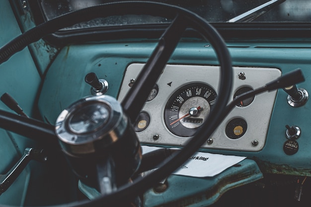 Close-up shot van een zwart stuurwiel binnenkant van een blauwe auto