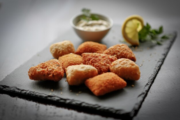 Close-up shot van gebakken aardappel kaas ballen of kroketten over donkere stenen bord