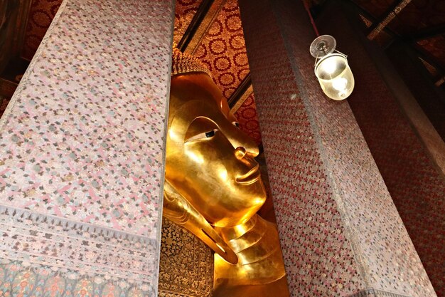 Close-up shot van het gouden standbeeld van Boeddha in Wat Pho Buddhist tempelcomplex, Thailand