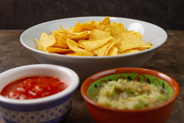 Close-up shot van ketchup, groentesalade en chips in kommen