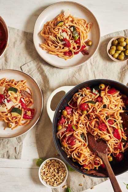 Close-up shot van pasta met groenten en ingrediënten op een witte tafel