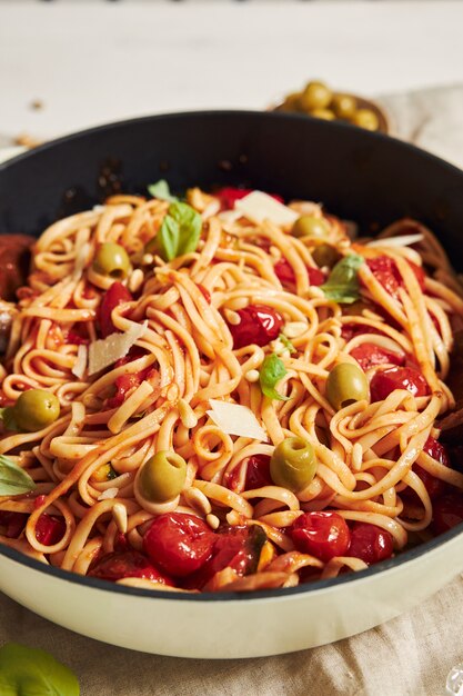 Close-up shot van pasta met groenten en ingrediënten op een witte tafel