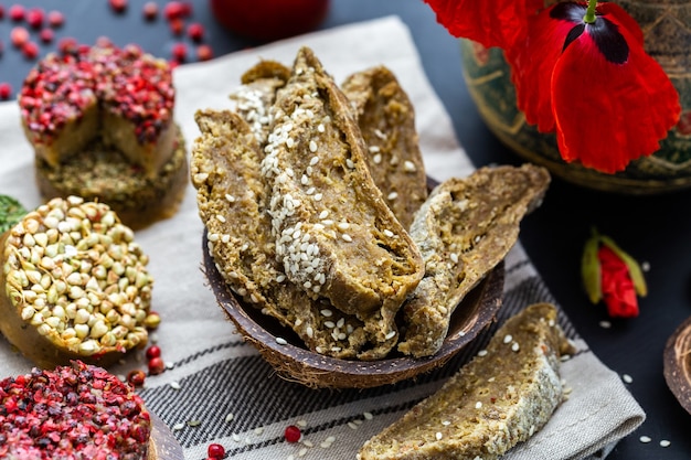 Close-up shot van rauw veganistisch brood met papavers op een donker tafelblad