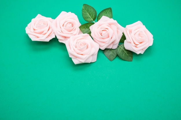 Close-up shot van roze rozen geïsoleerd op een groene achtergrond met kopie ruimte