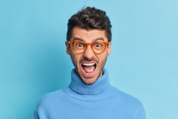 Gratis foto close-up shot van verontwaardigde geïrriteerde man houdt mond wijd geopend schreeuwt met ergernis drukt negatieve emoties uit