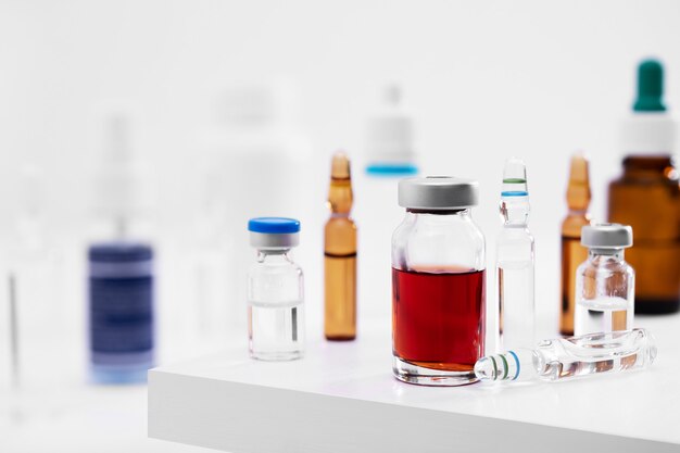 Close-up shot van verschillende glazen flesjes met vloeistoffen op een wit oppervlak in een lab