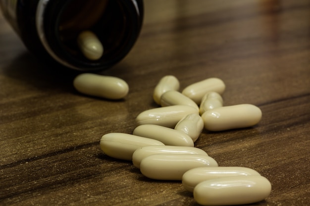 Gratis foto close-up shot van witte geneeskunde capsules op een houten oppervlak