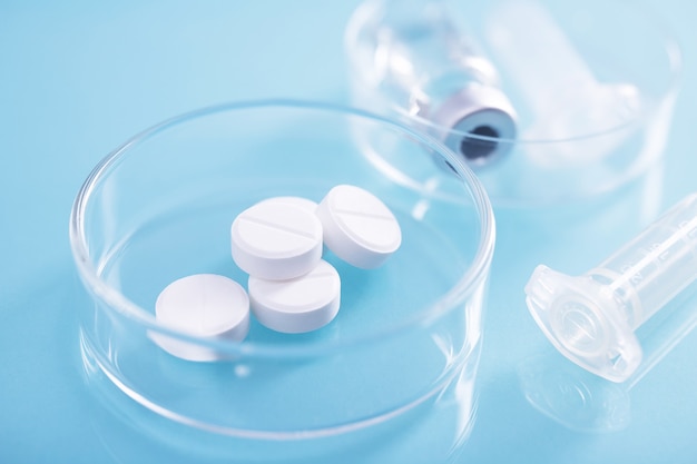 Close-up shot van witte pillen in een glazen schaal in een laboratorium