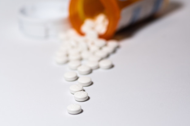 Close-up shot van witte ronde pillen op een witte ondergrond
