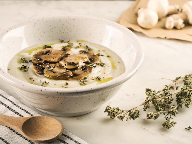 Close-up shot van witte soep, romig en rustiek met champignons op tafel