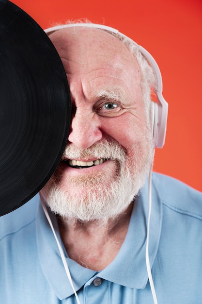 Close-up smiley seniro met muziekplaten