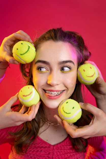 Close-up smiley tiener met tennisballen