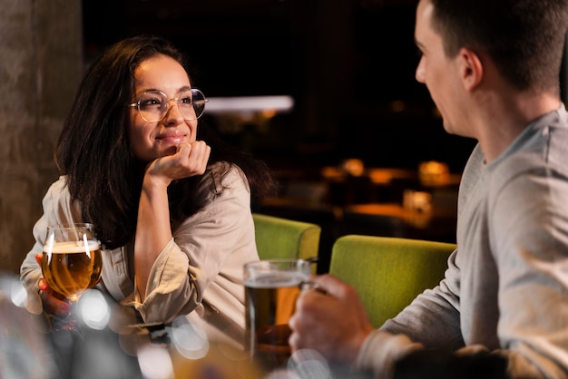 Gratis foto close-up smiley vrouw en man met bier