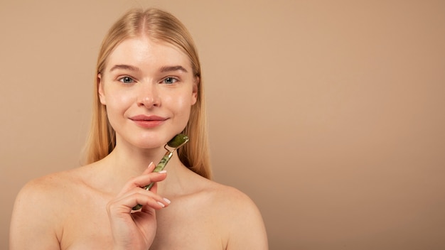 Close-up smiley vrouw gezicht masseren met tool