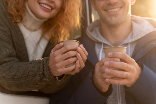 Gratis foto close-up smileypaar met koffiekopjes