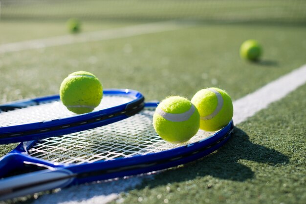 Close-up tennis rackets en ballen op de grond