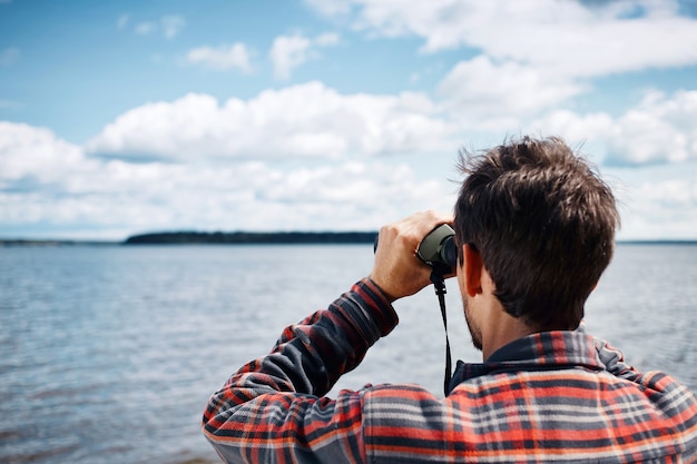 Gratis foto close-up terug portret van man kijkt door een verrekijker