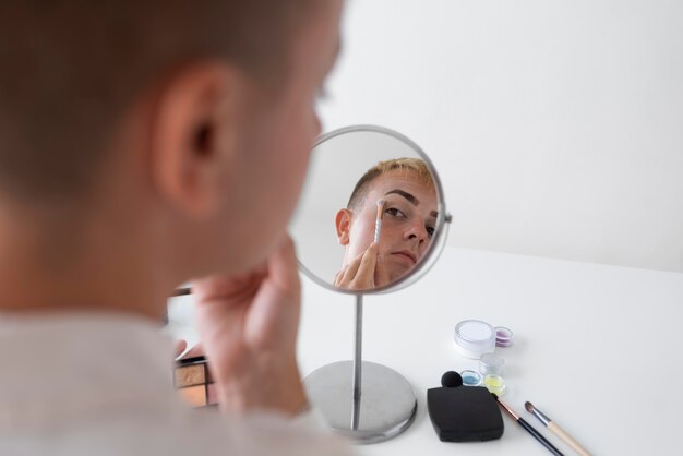 Close-up transgender in de spiegel kijken