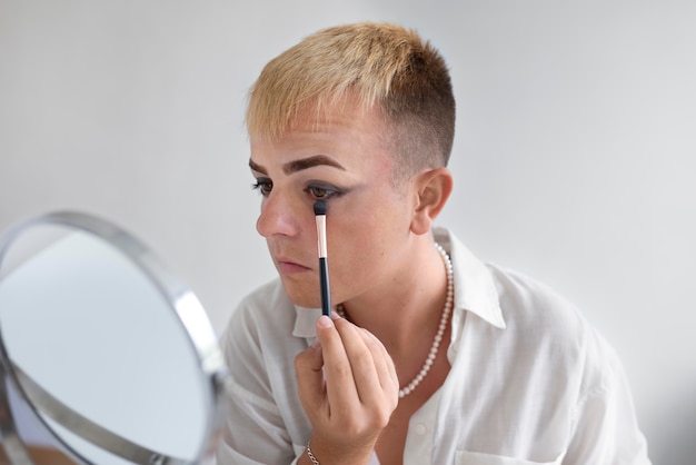 Close-up transgender met make-upborstel