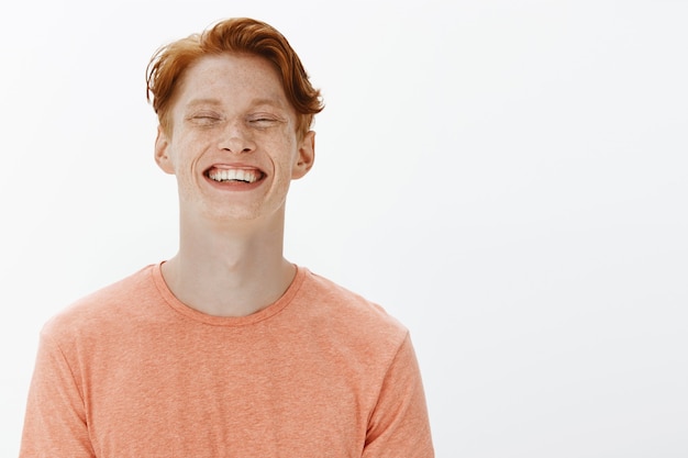 Gratis foto close-up van aantrekkelijke zorgeloze man lachen en glimlachen, plezier maken