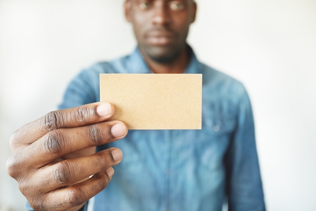 Gratis foto close-up van afrikaanse man handen met visitekaartje