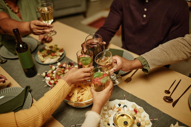 Close up van afro-amerikaanse familie rammelende glazen terwijl u geniet van een etentje thuis