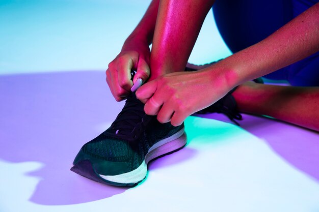 Close-up van atleet die haar schoenen bindt