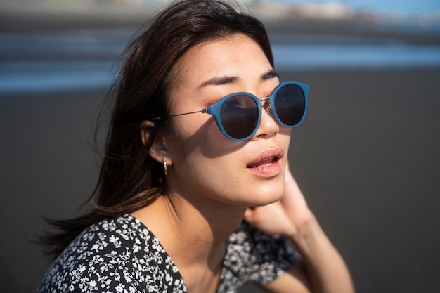 Gratis foto close-up van aziatische vrouw met zonnebril