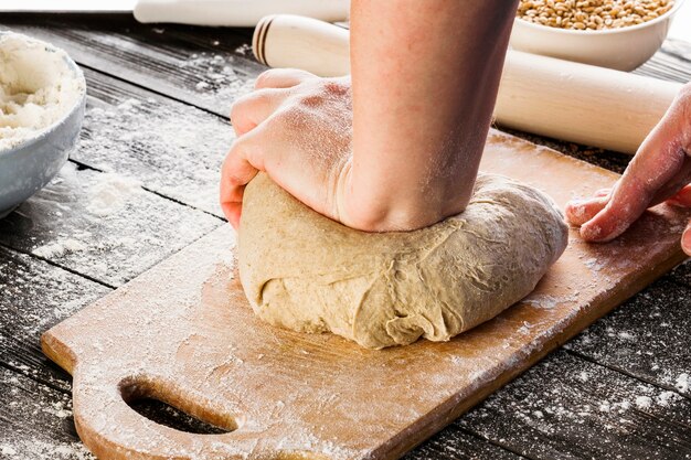 Close-up van bakkers hand kneden deeg voor brood