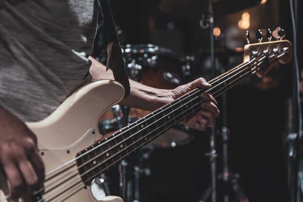 Close up van basgitaar op wazig donkere achtergrond kopie ruimte.