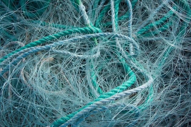 Close-up van blauwe touwen en visnetten op elkaar onder het zonlicht