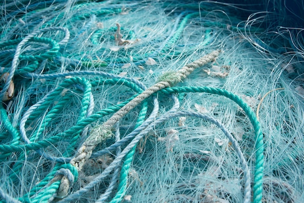 Close-up van blauwe touwen en visnetten op elkaar onder het zonlicht