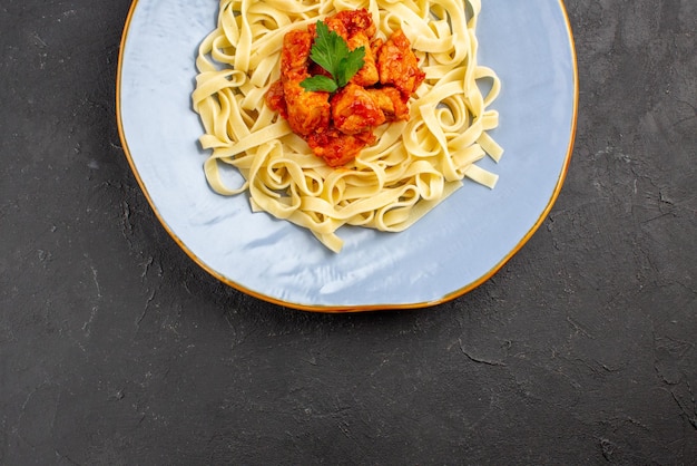 Close-up van bovenaanzicht smakelijke pasta smakelijke pasta met vlees op de donkere tafel