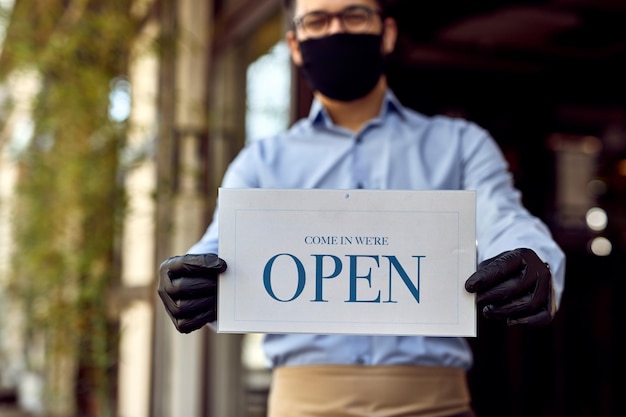 Gratis foto close-up van café-eigenaar met open bord na coronavirusepidemie