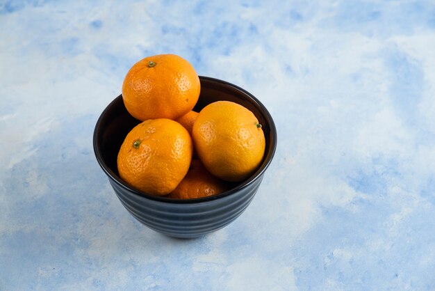 Close-up van Clementine mandarijnen in zwarte kom
