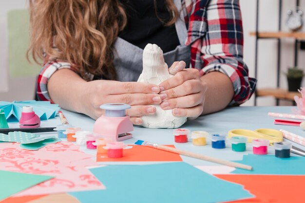 Close-up van craftswoman kneden witte klei op tafel