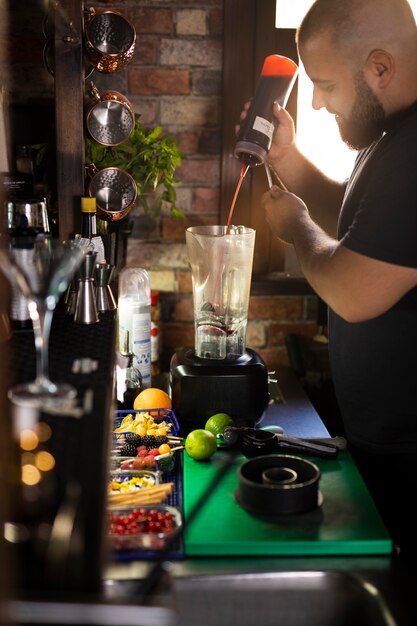 Close-up van de barman die een heerlijke drank maakt.
