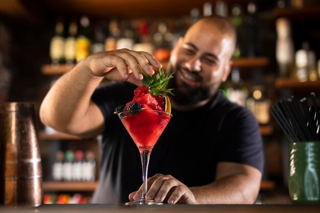 Close-up van de barman die een heerlijke drank maakt.
