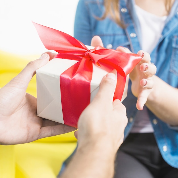 Close-up van de hand die van een man heden aan zijn vrouw geeft