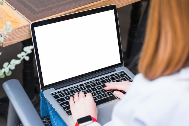 Close-up van de hand die van een vrouw aan laptop werkt