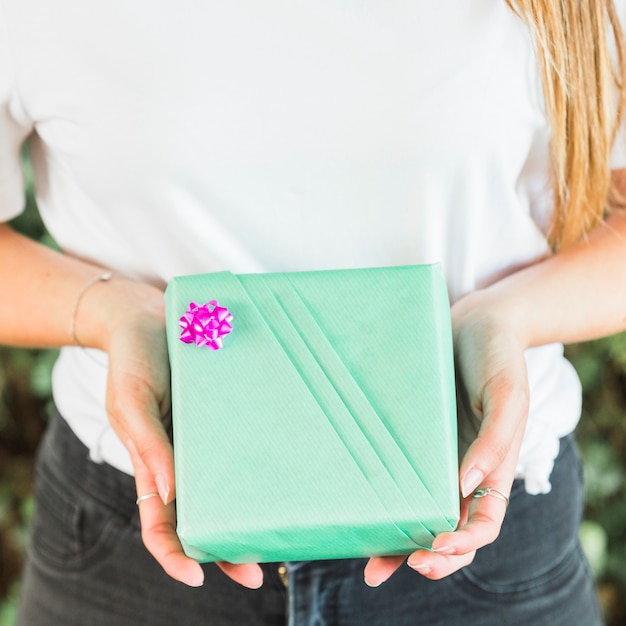 Close-up van de hand die van een vrouw de groene doos van de verjaardagsgift houdt