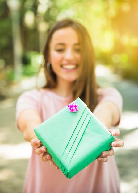 Gratis foto close-up van de hand die van een vrouw groene giftdoos houdt