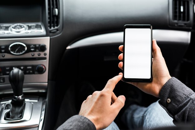 Close-up van de hand met behulp van smartphone met witte weergave scherm zitten in de auto