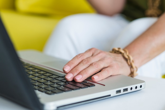 Close-up van de hand van de vrouw op laptop toetsenbord