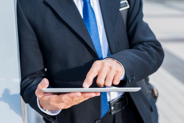 Close-up van de hand van een zakenman die digitale tablet gebruikt