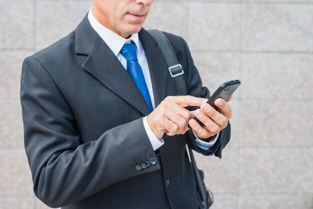 Close-up van de hand van een zakenman met behulp van de mobiele telefoon